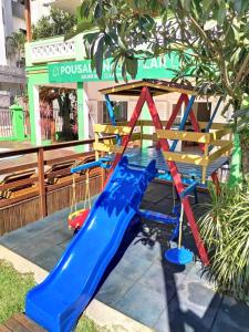 um parque infantil com um escorrega azul num quintal em POUSADA NOSSO LAR no Guarujá
