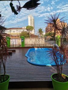 uma piscina num deque de madeira com plantas em POUSADA NOSSO LAR no Guarujá