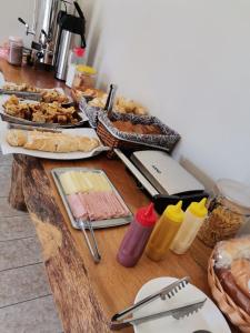 een houten tafel met voedsel en andere voedingsmiddelen erop bij POUSADA NOSSO LAR in Guarujá