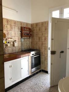 a small kitchen with a stove and a sink at Une maison djerbienne in Houmt Souk
