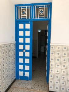 a toy room with a blue and white door at Une maison djerbienne in Houmt Souk