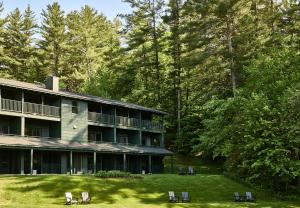 a large building with chairs in the grass at Bluebird Cady Hill Lodge in Stowe