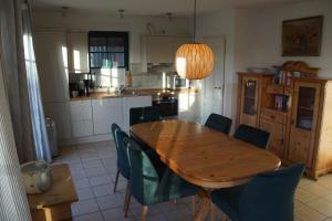 cocina con mesa de madera y sillas verdes en Linnea, en Brasilien