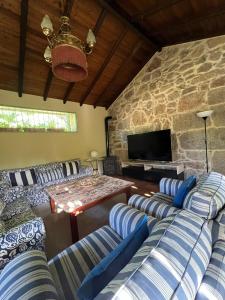 una sala de estar con sofás y una pared de piedra. en Saramagoso, en Meis