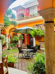a patio with a table and chairs and an umbrella at Los Arrayanes in Oaxaca City