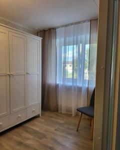 a room with a closet and a chair and a window at The entire comfortable apartment in Rakvere