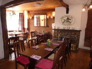 a dining room with tables and chairs and a fireplace at The Tally Ho in Hungerford