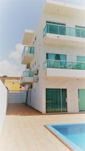 an apartment building with a swimming pool in front of it at Pousada Diana Maragogi in Maragogi