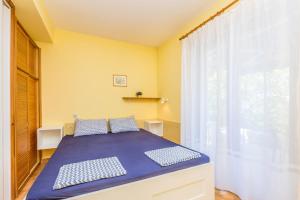 a bedroom with a bed with blue sheets and a window at Apartments with a parking space Njivice, Krk - 5325 in Njivice