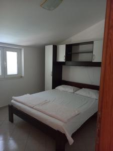 sypialnia z dużym łóżkiem z białymi prześcieradłami w obiekcie Apartments by the sea Tkon, Pasman - 5840 w mieście Tkon