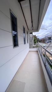einen leeren Balkon eines weißen Gebäudes mit Fenstern in der Unterkunft HOTEL BOUTIQUE CRISTOFF in Apartadó