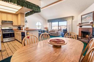 a kitchen and living room with a wooden table and chairs at 013 - Mountain Haven Condo in Big Bear Lake