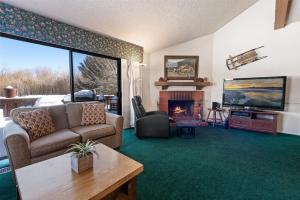 013 - Mountain Haven Condo في بيغ بير لاكي: غرفة معيشة مع أريكة ومدفأة
