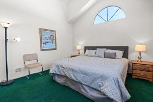 um quarto com uma cama, uma janela e uma cadeira em 013 - Mountain Haven Condo em Big Bear Lake