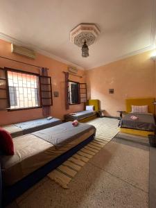 Riad dar sahrawi في مراكش: غرفة نوم بثلاث اسرة في غرفة
