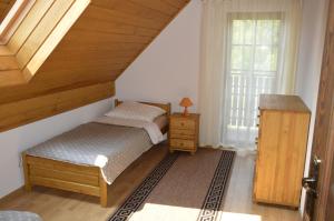 a bedroom with two beds and a staircase at Dom na Mazurach in Rydzewo