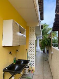 a kitchen with a sink and a yellow wall at Casa amarela in Campos