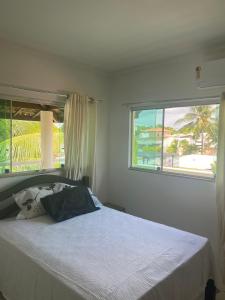 a bedroom with a bed and a large window at Casa amarela in Campos