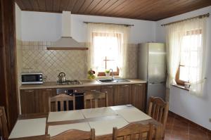 a kitchen with a table and a refrigerator at Dom na Mazurach in Rydzewo