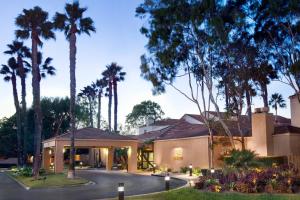 a house with palm trees and a driveway at Courtyard Los Angeles Torrance/Palos Verdes in Torrance