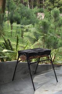a black table sitting in front of a garden at Sausau Garden, a pefect retreat for relaxing, close to Noi Bai airport in Sóc Sơn
