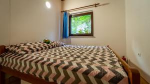 a bed in a room with a window at Apartments with parking space Lokve, Gorski kotar - 20236 in Lokve