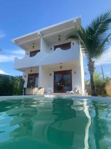 a villa with a swimming pool in front of a house at Maceió Kite House in Camocim