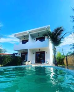 a villa with a swimming pool in front of a house at Maceió Kite House in Camocim