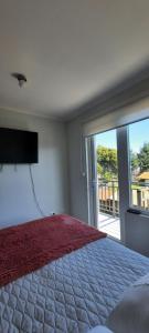 une chambre avec un grand lit avec une télévision à écran plat dans l'établissement Pucón Soñado Te Espera, à Pucón