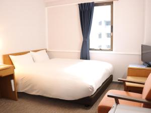 um quarto de hotel com uma cama e uma janela em Hotel New Saitama em Saitama
