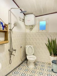 a bathroom with a toilet and a shower with a window at Hat De homestay in Xuan An