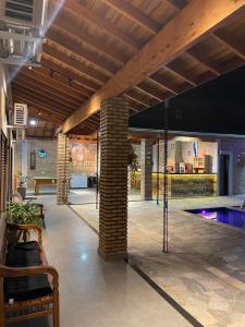 a lobby with a swimming pool and a brick pillar at Chácara ilha do Sol com Piscina aquecida 5km do thermas in Olímpia