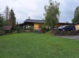 a yard in front of a house with a playground at Noclegi NADZAMCZE in Czorsztyn