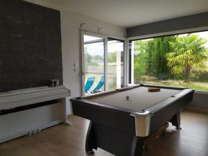 a room with a pool table and a window at norman villa on d-day beach with heated pool, in Amfréville