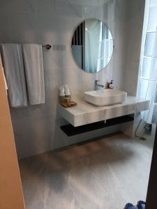 a white bathroom with a sink and a mirror at Room in Wyndham Thanh Thuy Hot Spring MyHome in La Phu