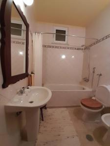 een badkamer met een wastafel, een toilet en een bad bij Casa do Avô Lopes in Tomar