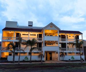 a large building with palm trees in front of it at Hotel & Cabañas Malinche in Huamantla
