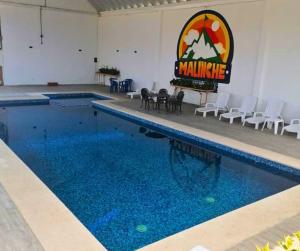 une piscine avec des chaises et un panneau indiquant mammammamite dans l'établissement Hotel & Cabañas Malinche, à Huamantla
