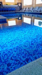 una piscina con azulejos azules en el suelo en Hotel & Cabañas Malinche en Huamantla