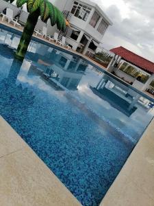 una piscina con una palmera frente a un edificio en Hotel & Cabañas Malinche en Huamantla