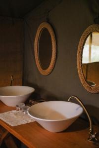 a bathroom with two sinks and two mirrors on a counter at Enkusero Mara in Aitong