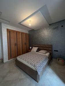 um quarto com uma cama grande num quarto em Logement moderne et neuf entièrement équipé em Fez