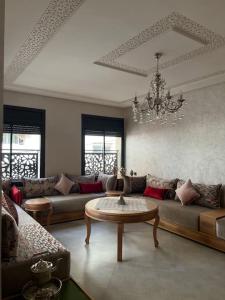 uma sala de estar com um sofá e uma mesa em Logement moderne et neuf entièrement équipé em Fez