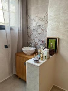 uma casa de banho com um lavatório e um balcão com um espelho em Logement moderne et neuf entièrement équipé em Fez