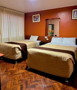 Habitación de hotel con 2 camas y espejo en Posada de Belén, en Arequipa