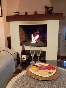 a table with a plate of food and wine glasses and a fireplace at Alojamiento Rural San Antonio in Ubaté