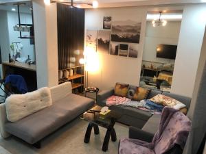 a living room with a couch and two chairs at Comfy Room With Single Sized Bed, Study Space, Closet, and WiFi in Manila