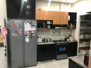 a kitchen with a refrigerator and a stove at Comfy Room With Single Sized Bed, Study Space, Closet, and WiFi in Manila