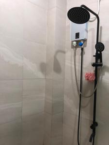a shower with a shower head in a bathroom at Comfy Room With Single Sized Bed, Study Space, Closet, and WiFi in Manila