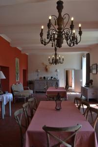 a dining room with a table and chairs and a chandelier at Domaine de Ceyrac in Conqueyrac